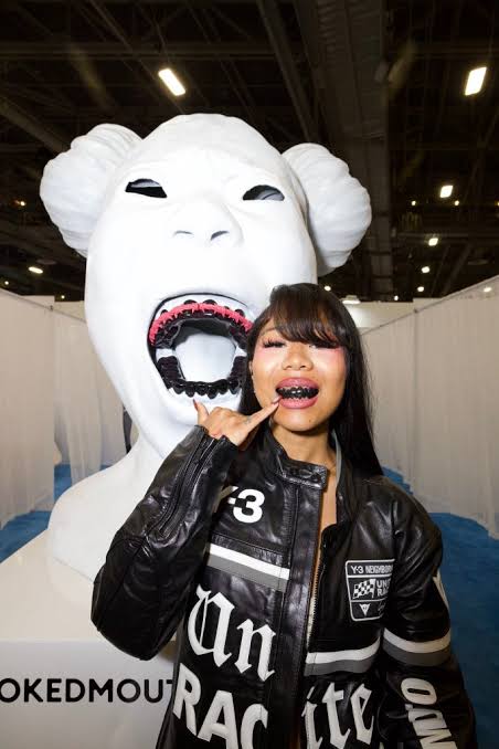 Sukii Baby with blackened teeth at a fashion/streetwear event